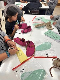 students painting moccasins