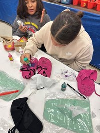 students painting moccasins