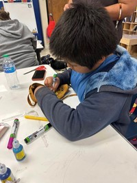 one student painting moccasins